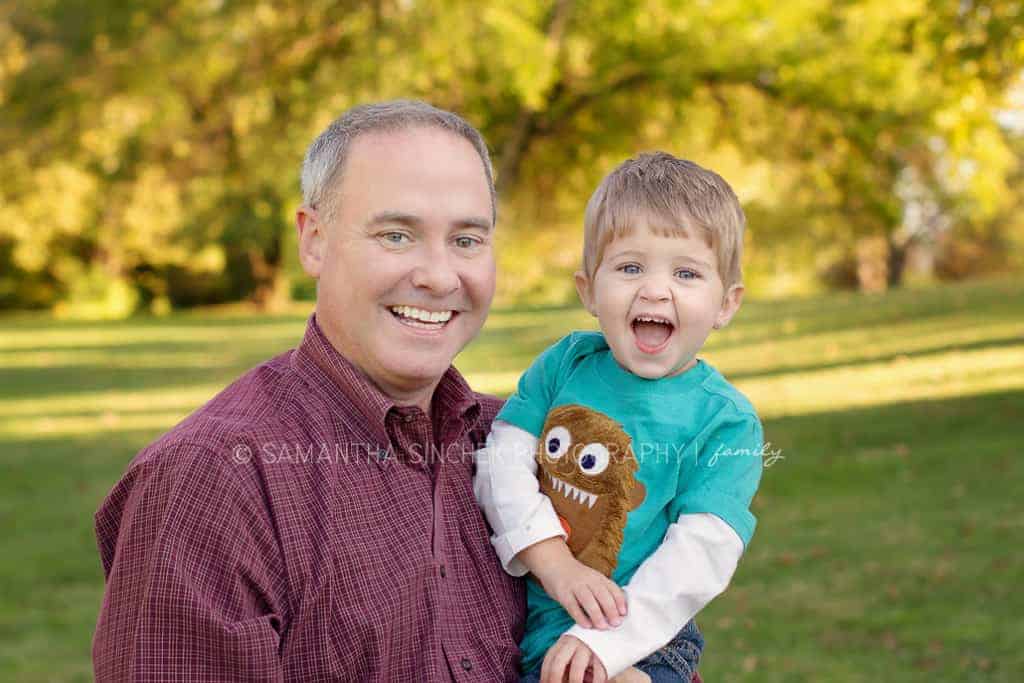 boy laughs while in fathers arms