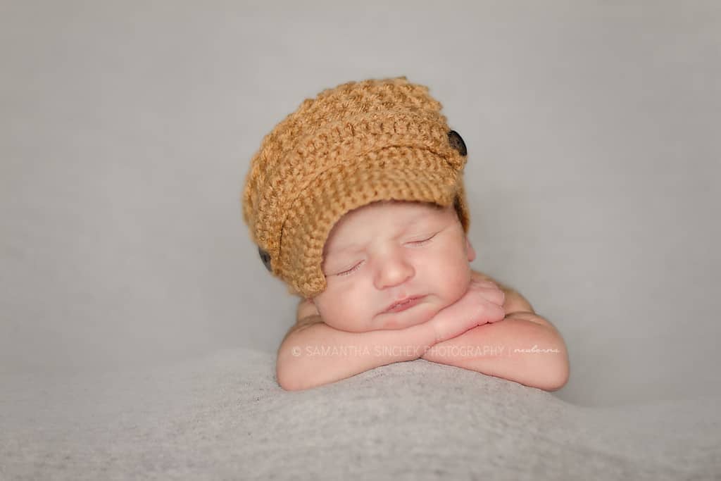 baby wears mustard color newsboy cab at newborn pictures in cincinnati