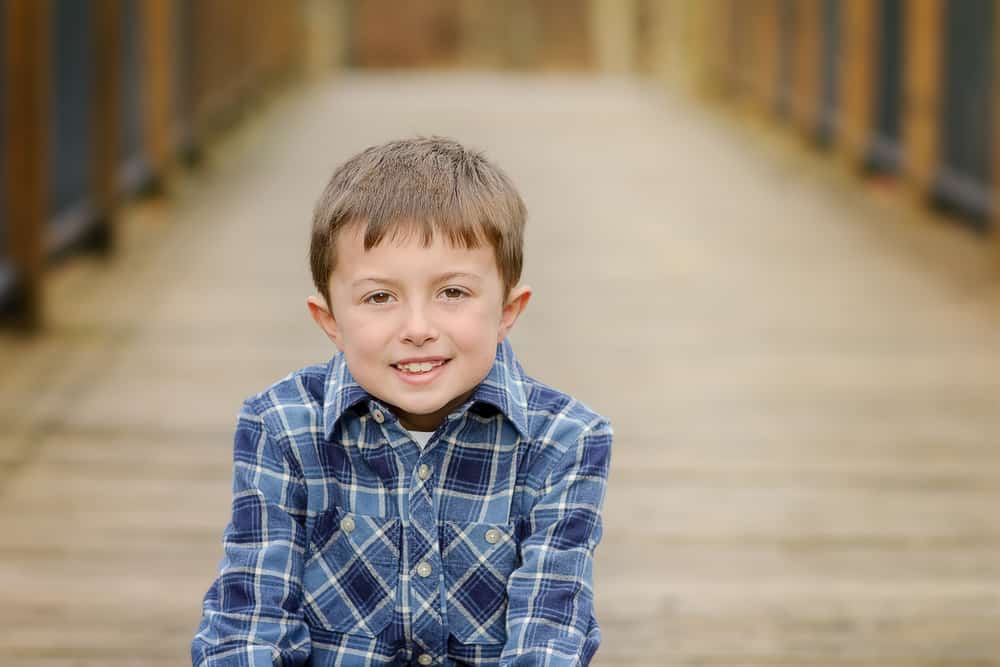 boy poses while sitting on a bridge at Sharon Woods Park in Cincinnati Ohio