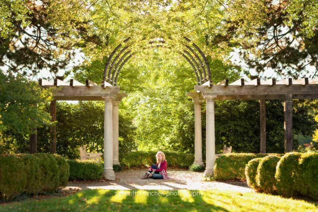panorama of high school senior sitting on grass on ault park