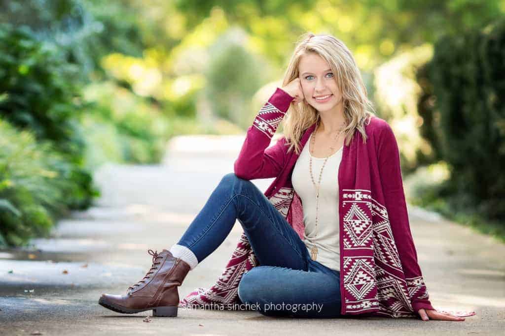 senior girl wears jeans and sweater during senior photo session