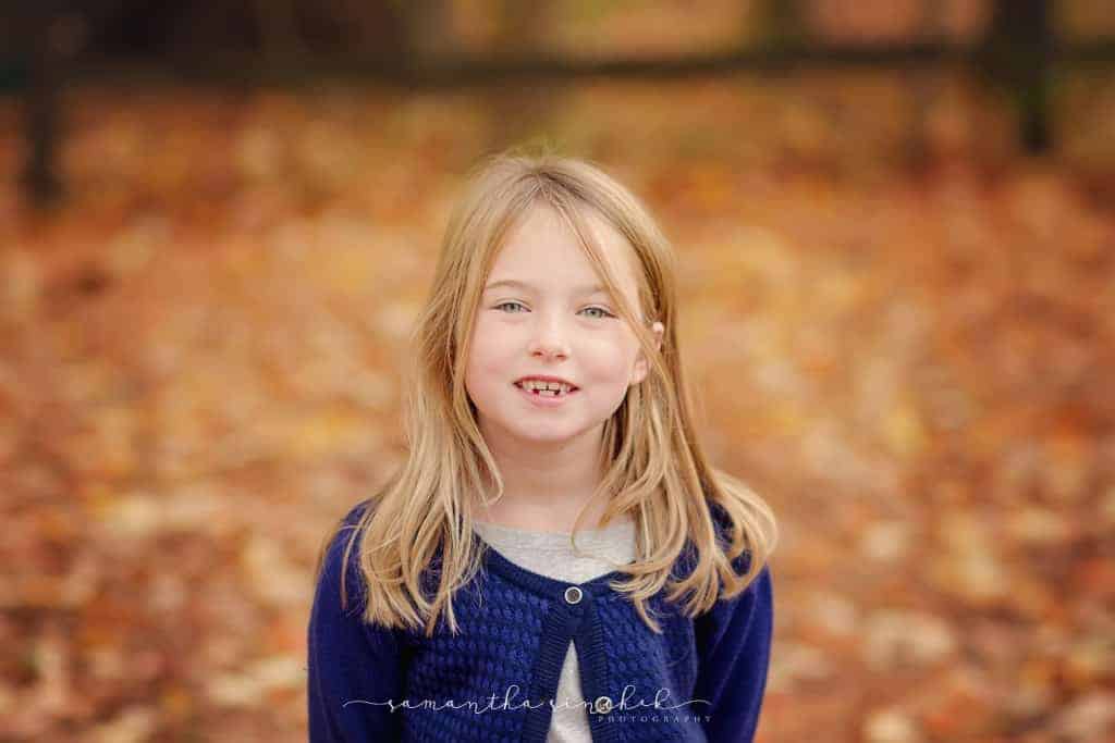girl wearing blue sweater smiles at camera