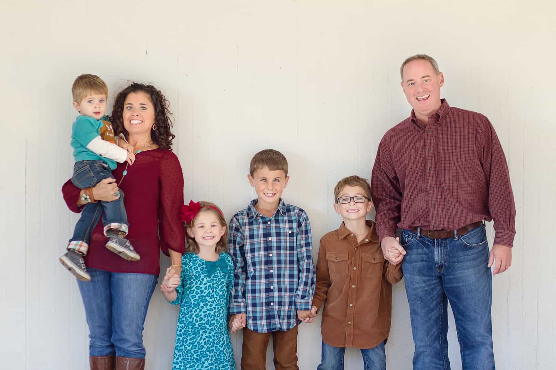 Parents and children stand in front of white wall at Cincinnati photo session