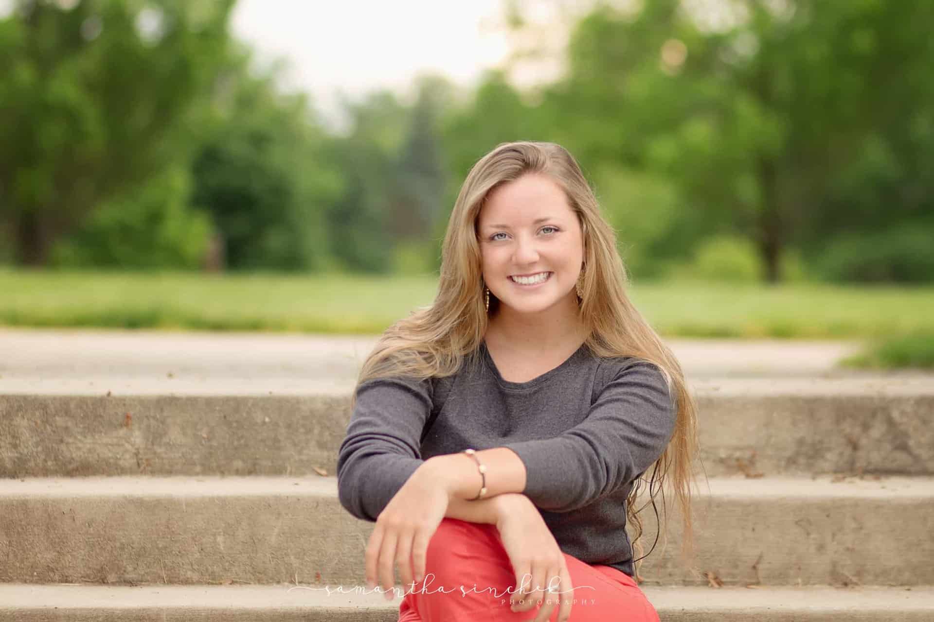 mason senior smiles on steps at ault park