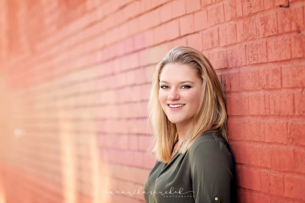 Mason senior girl leans against brick wall in OTR Cincinnati