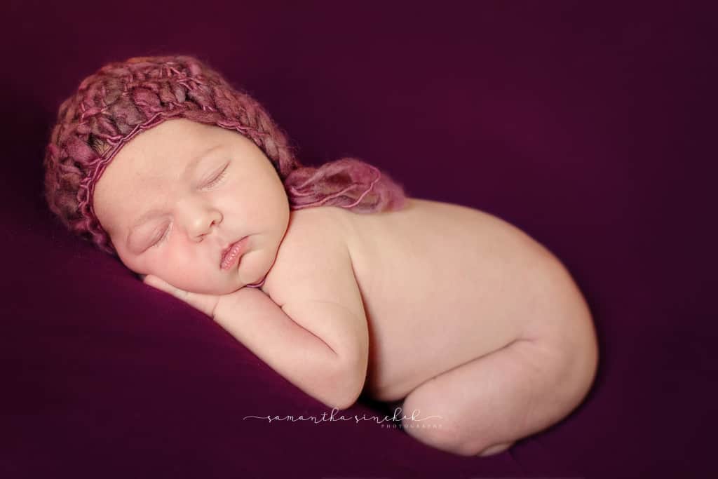 Newborn girl wears purple yarn bonnet from cincinnati