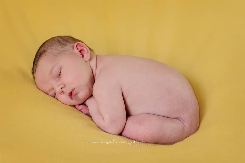 Newborn girl sleeps on yellow