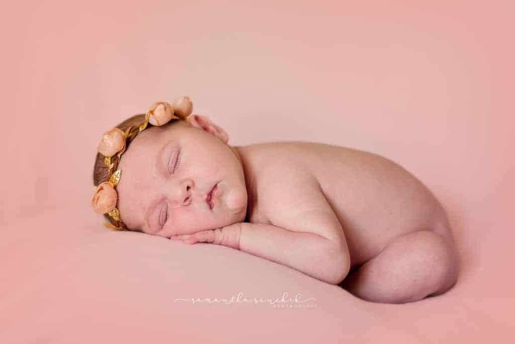 Baby girl from Cincinnati sleeps on pink fabric wearing pink and leather headband from target