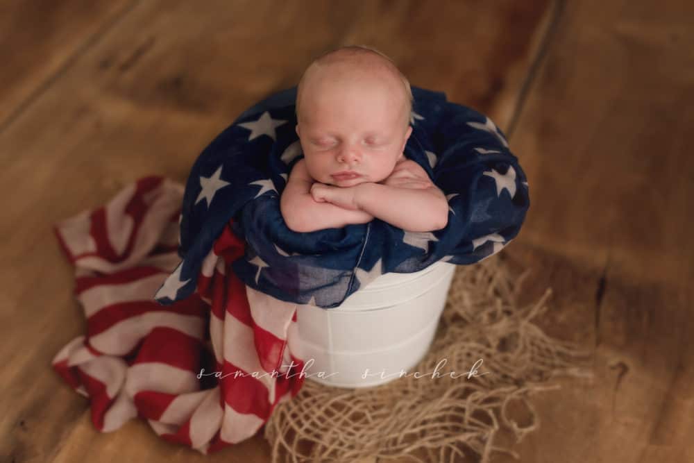 baby boy sleeps in bucket with American flag scarf wrapped around him 4th of July military army newborn cincinnati Ohio sinchek