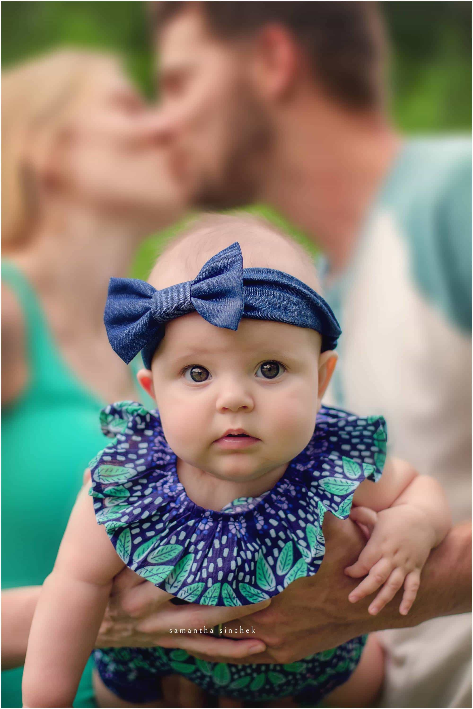mom and dad kiss in background of 6 month old baby at sharon woods