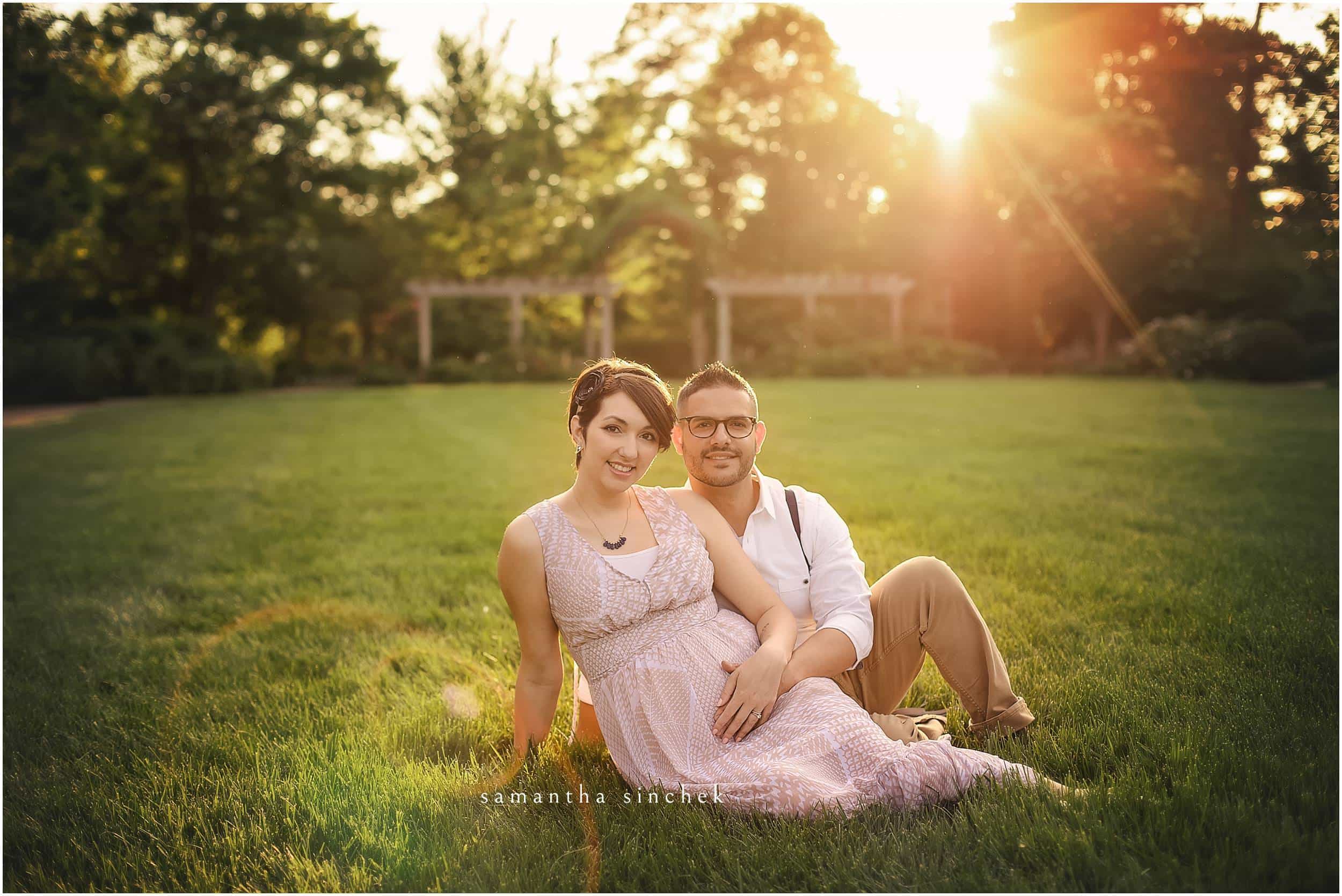 MATERNITY COUPLE SITS IN GRASS AT AULT PARK
