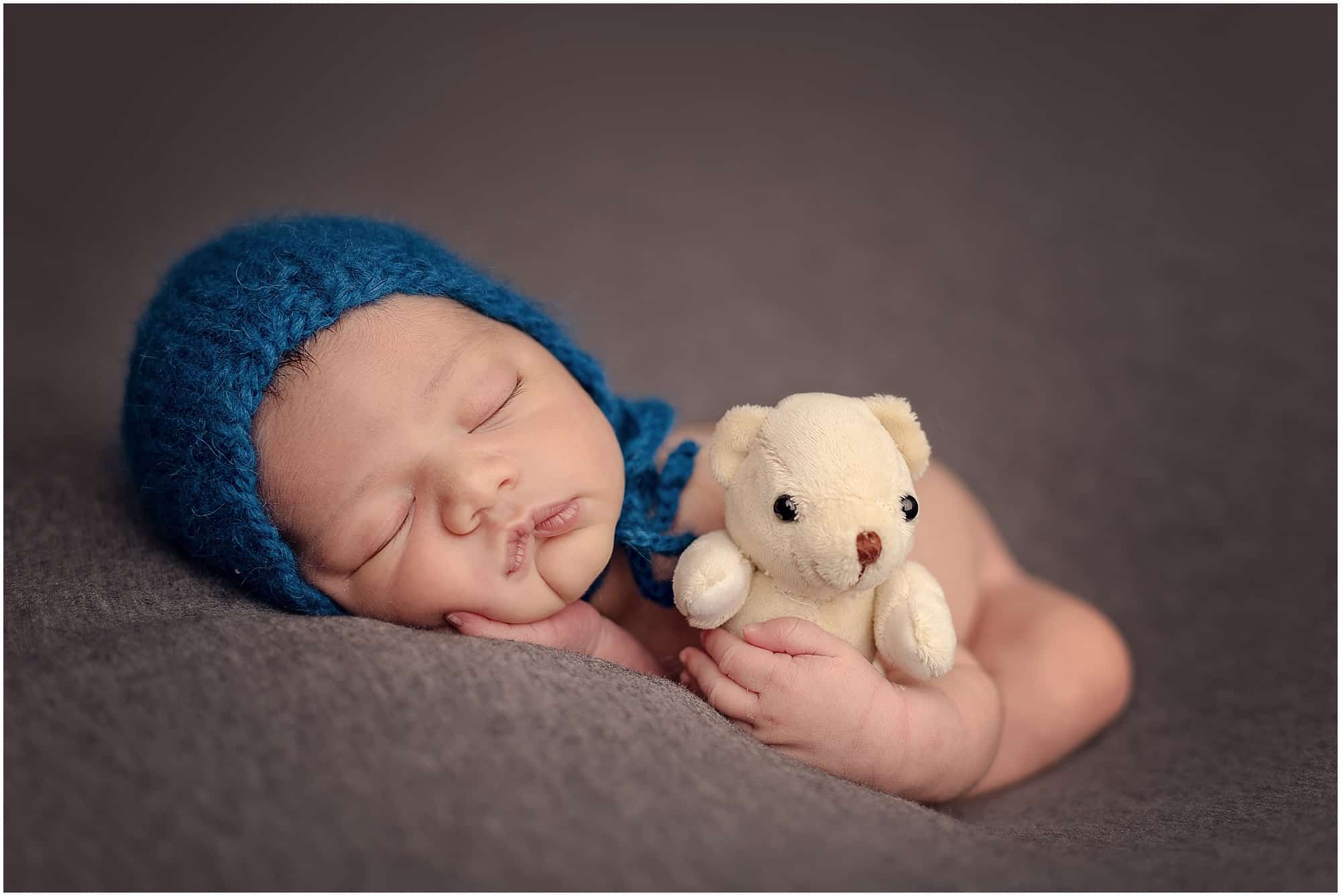 baby boy holds teddy bear at Cincinnati Ohio newborn session with Sinchek Photography