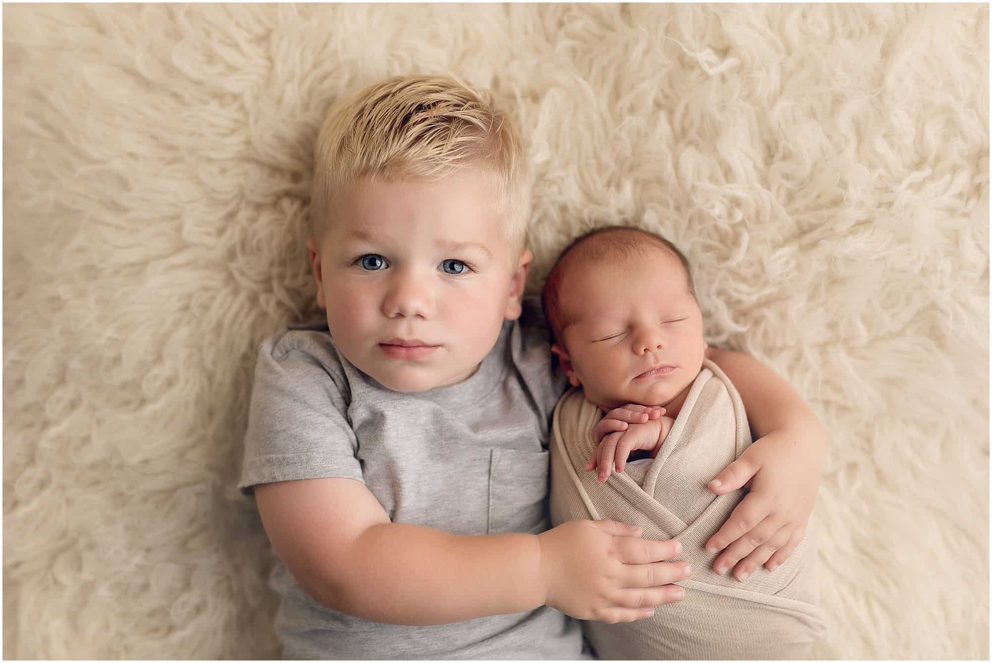 siblings hug at newborn pictures with award winning cincinnati newborn photographer Samantha sinchek 