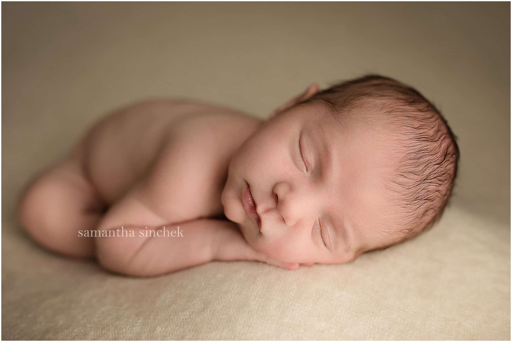 baby sleeping on cream backdrop during newborn pictures with Samantha sinchek