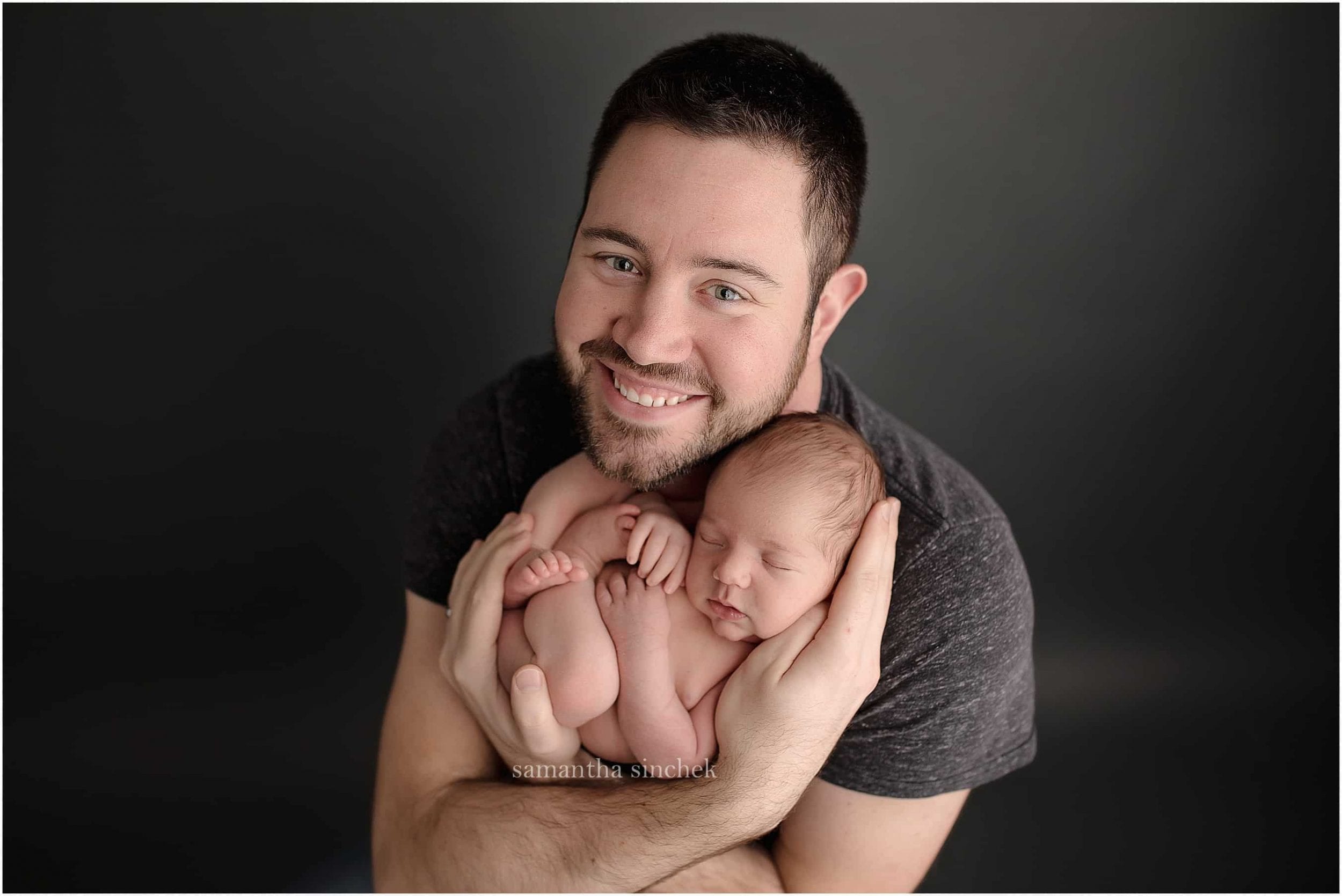 father holds newborn son at his pictures with cincinnati newborn photographer sinchek