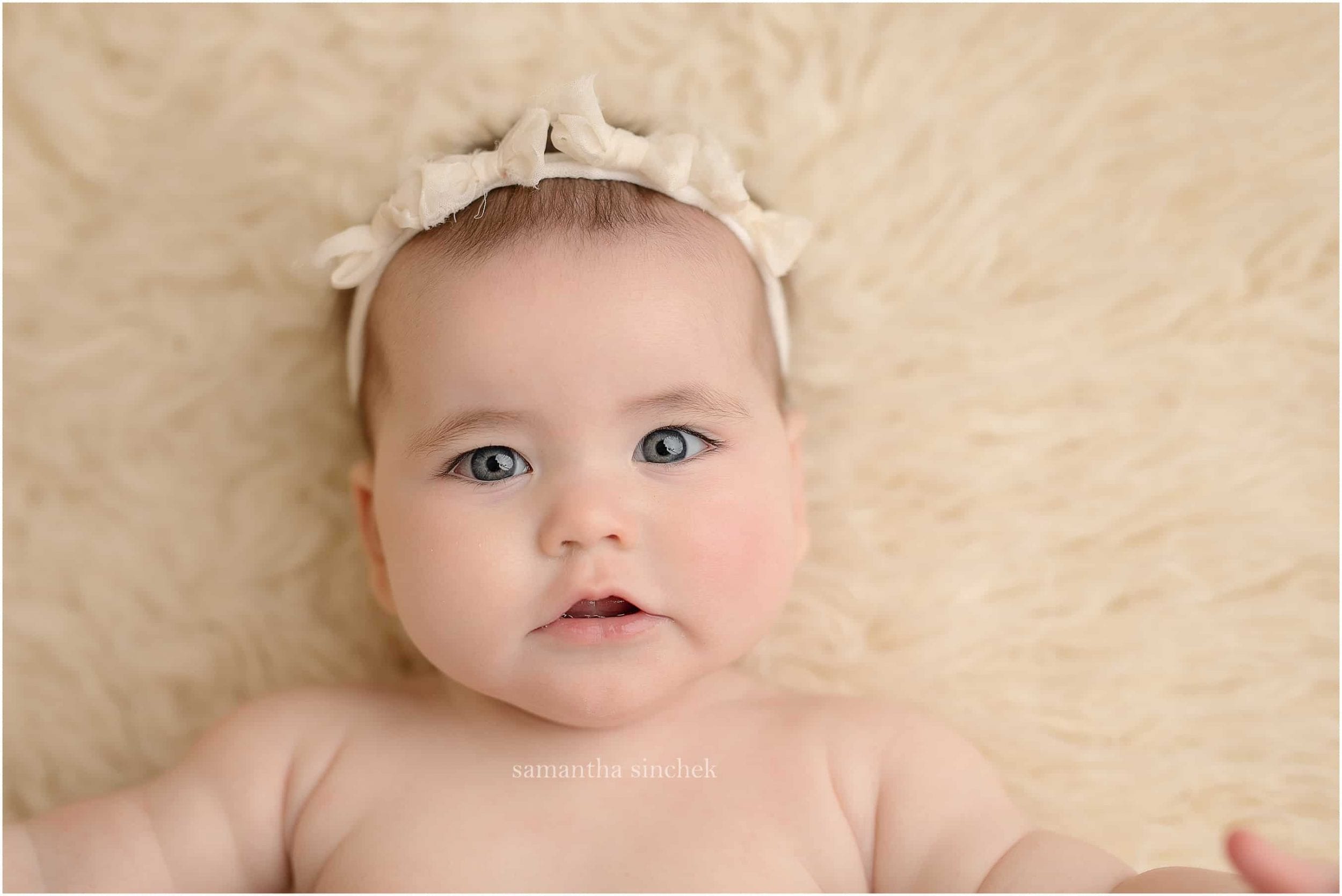 six month baby sits in wood bowl at photo session with Cincinnati photographer Samantha sinchek