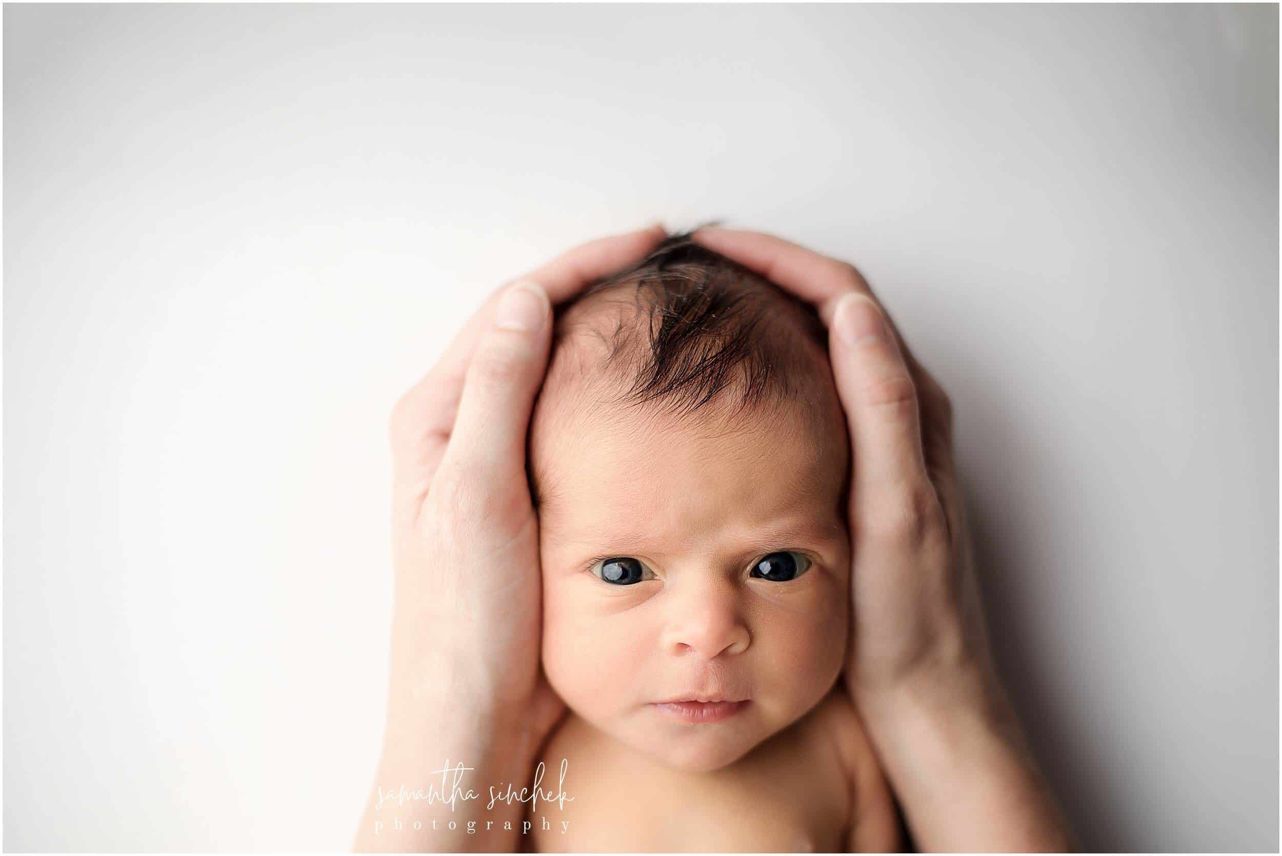 moms hands hold newborns awake head during pictures with cincinnati's best newborn photographer