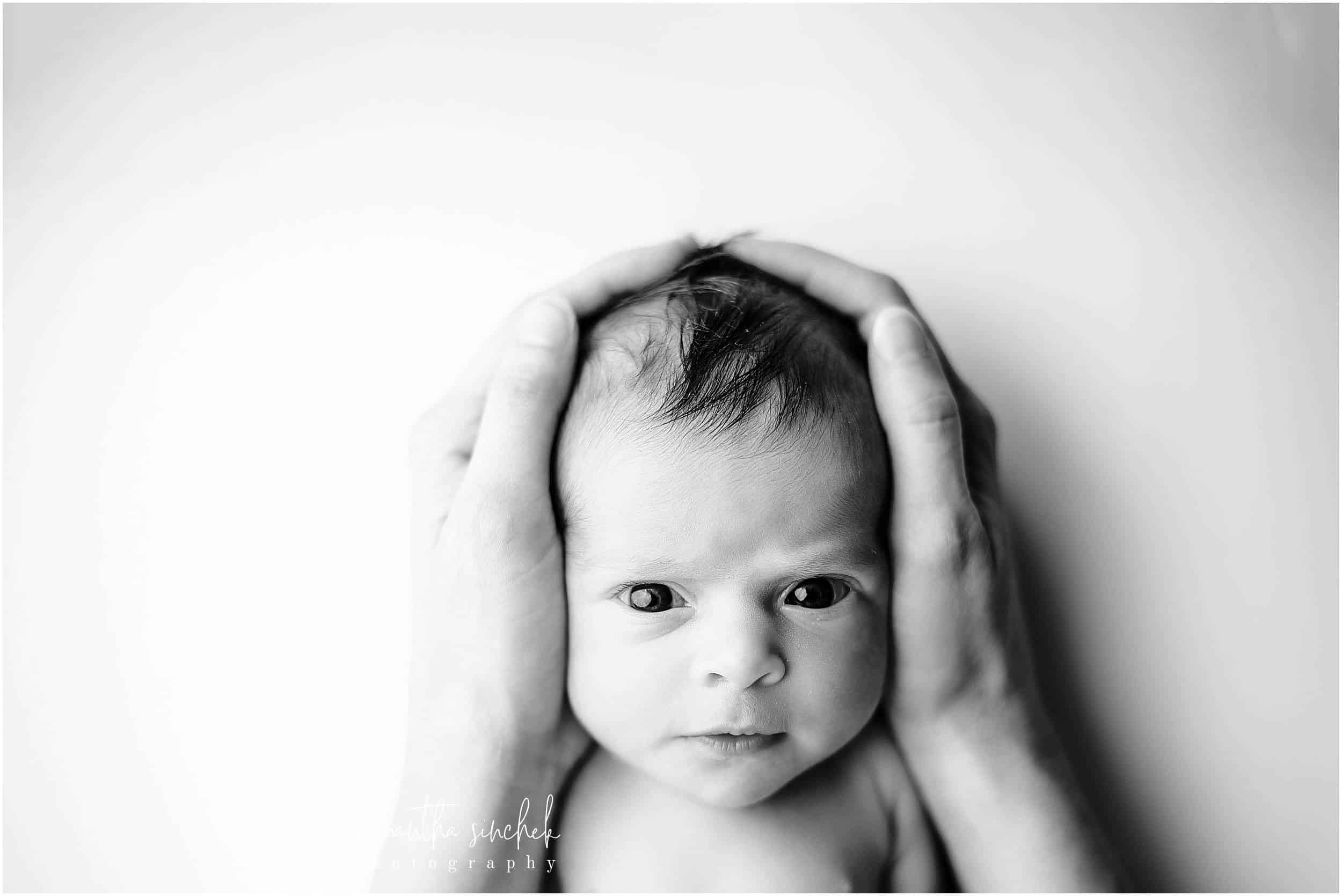 moms hands hold newborns awake head during pictures with cincinnati's best newborn photographer