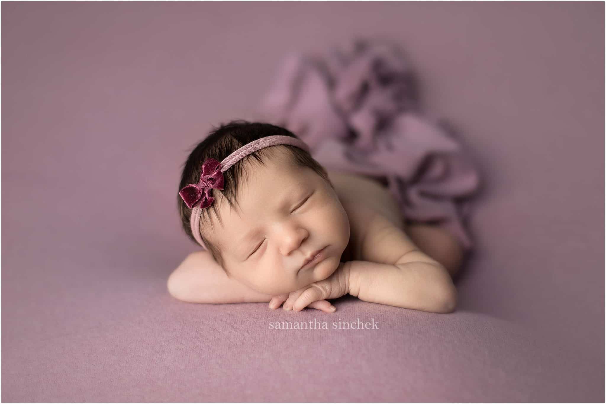 baby girl asleep on purple background with cincinnati newborn photographer Samantha Sinchek