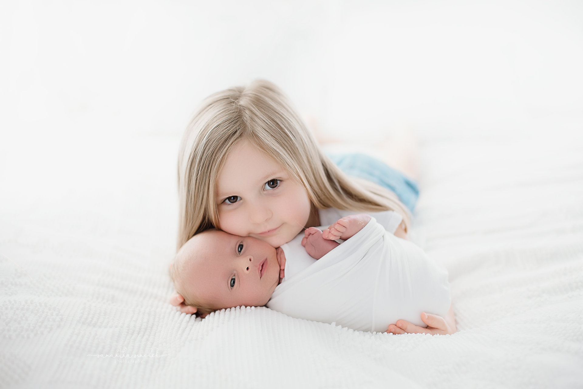big sister cuddles newborn brother at cincinnati newborn pictures with Samantha Sinchek