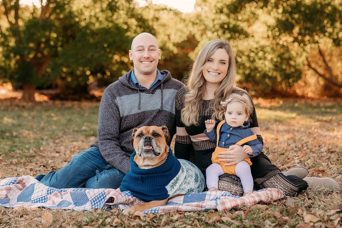 young child smiles an poses with parents in warm sunshine at Samantha Sinchek Photography in cincinnati Ohio