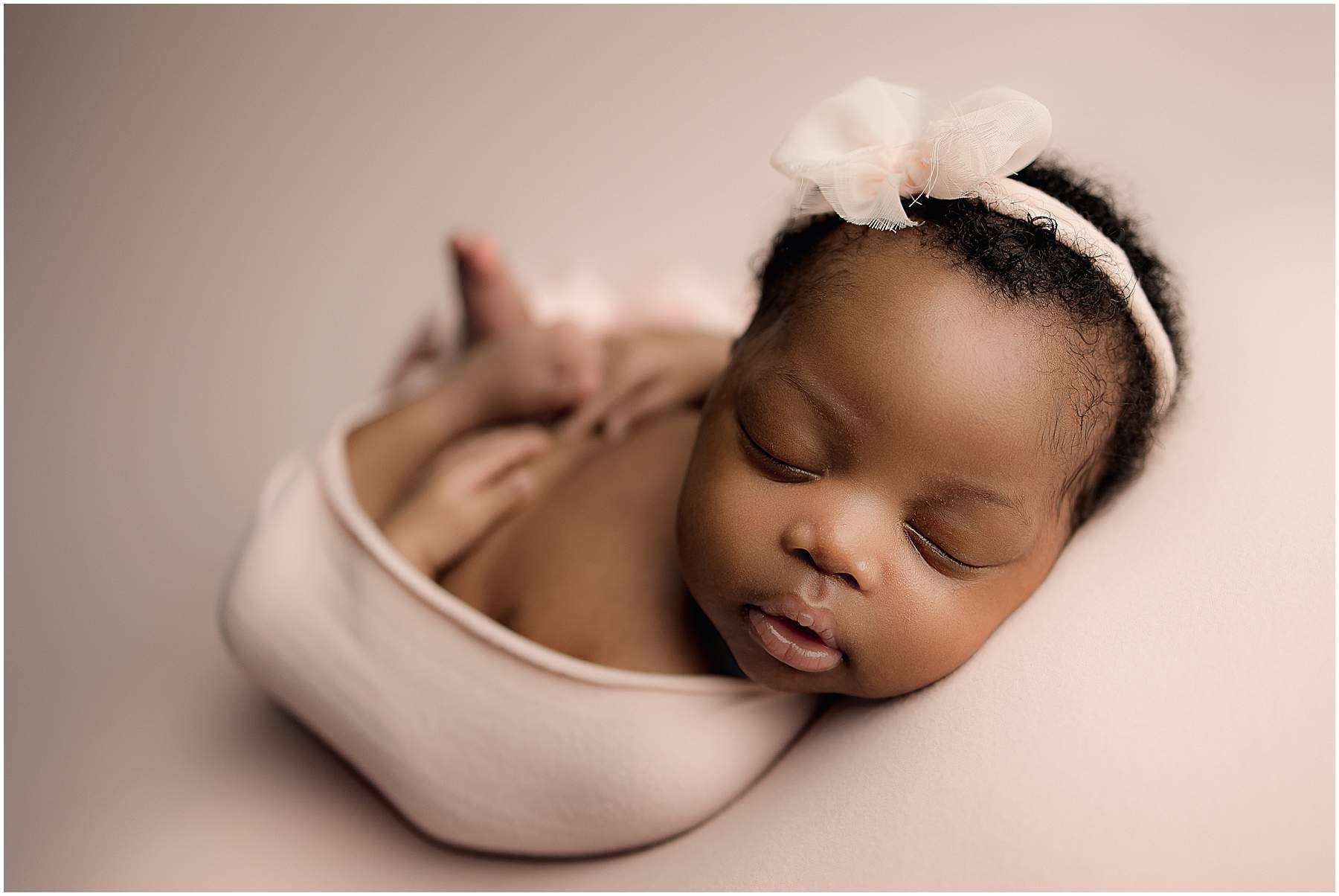 gorgeous newborn girl with pink bow sleeps at newborn pictures with Samantha Sinchek Photography